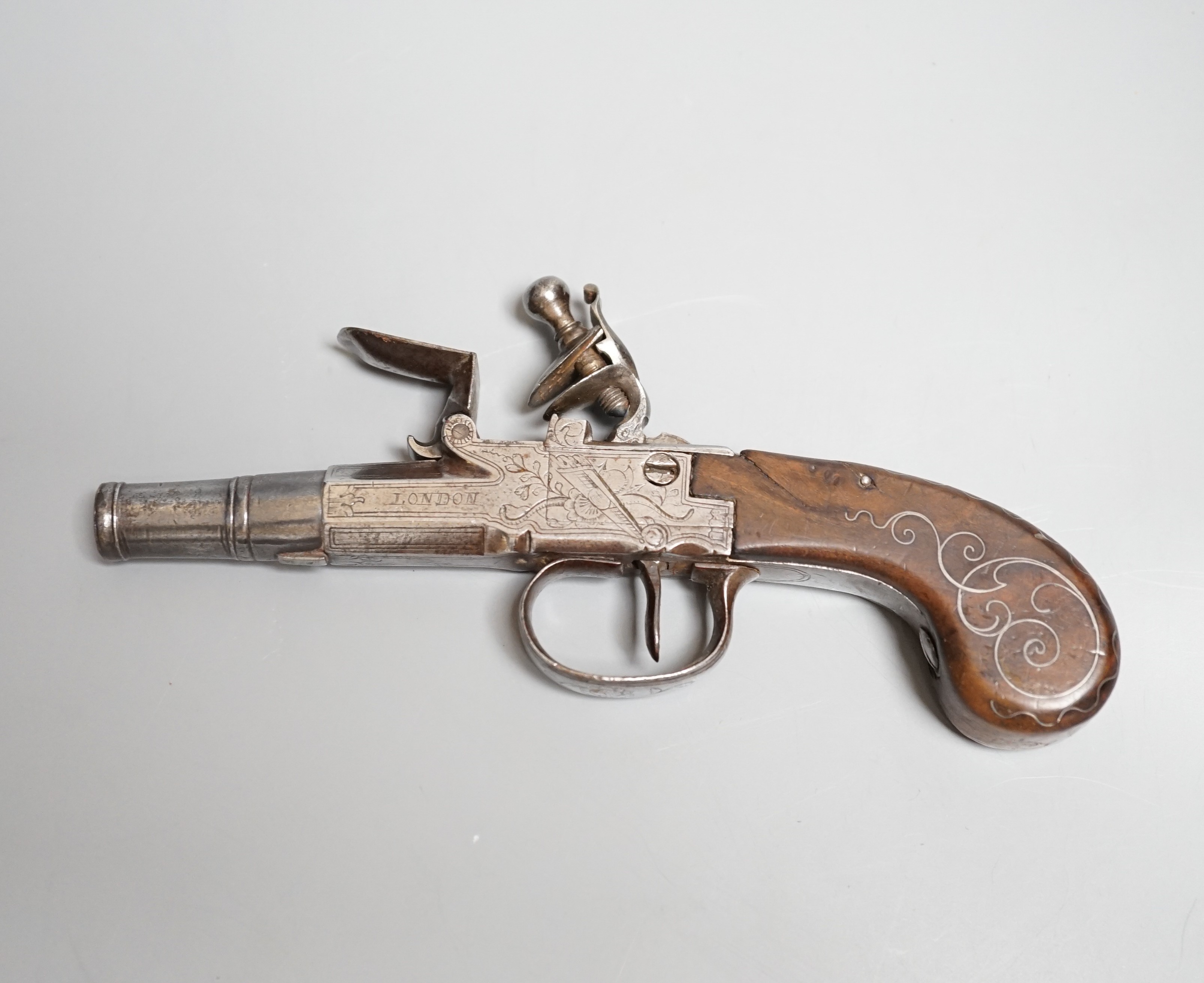 A Flintlock pocket pistol signed Segallas London, c.1770, turn off barrel, signed action engraved with trophies, trigger guard slides to lock mechanism, walnut grip with silver wire inlay, length 16.5cms.